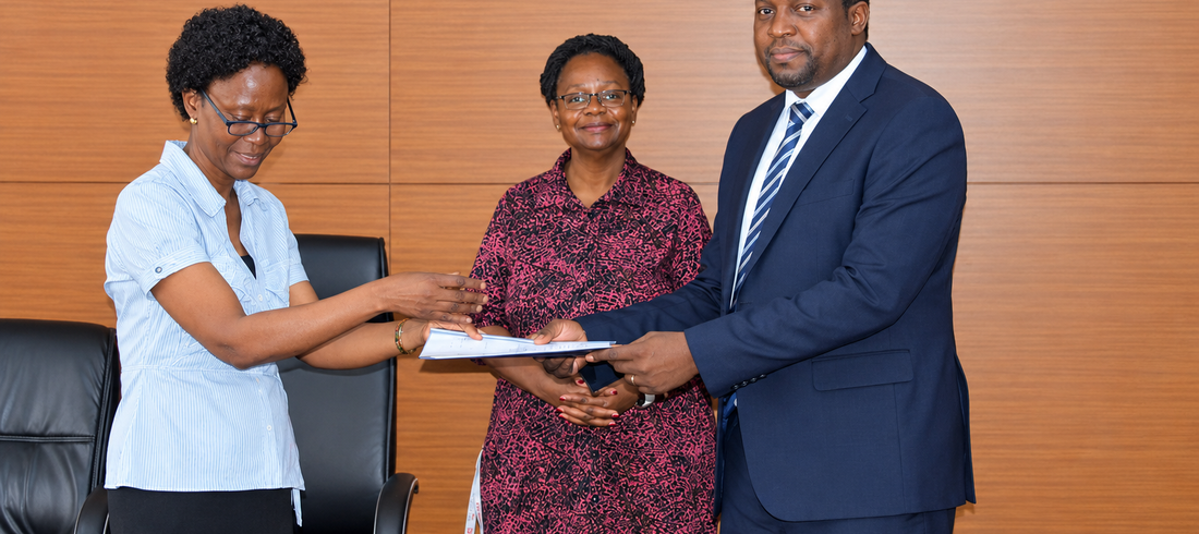 Outgoing Head of Department, Assoc. Prof. Robinah Kulabako (left), hands over the office to the incoming Head of Department, Dr. Philip Nyenje, during a ceremony held at CEDAT on October 5, 2026. In the centre is the Dean, School of Engineering, Assoc. Prof. Eng. Dorothy Okello.