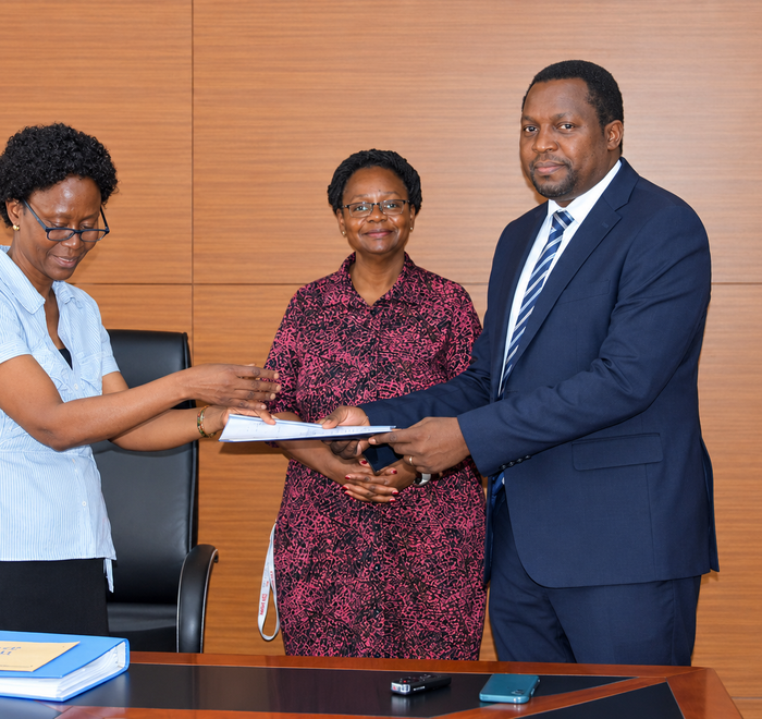 Outgoing Head of Department, Assoc. Prof. Robinah Kulabako (left), hands over the office to the incoming Head of Department, Dr. Philip Nyenje, during a ceremony held at CEDAT on October 5, 2026. In the centre is the Dean, School of Engineering, Assoc. Prof. Eng. Dorothy Okello.