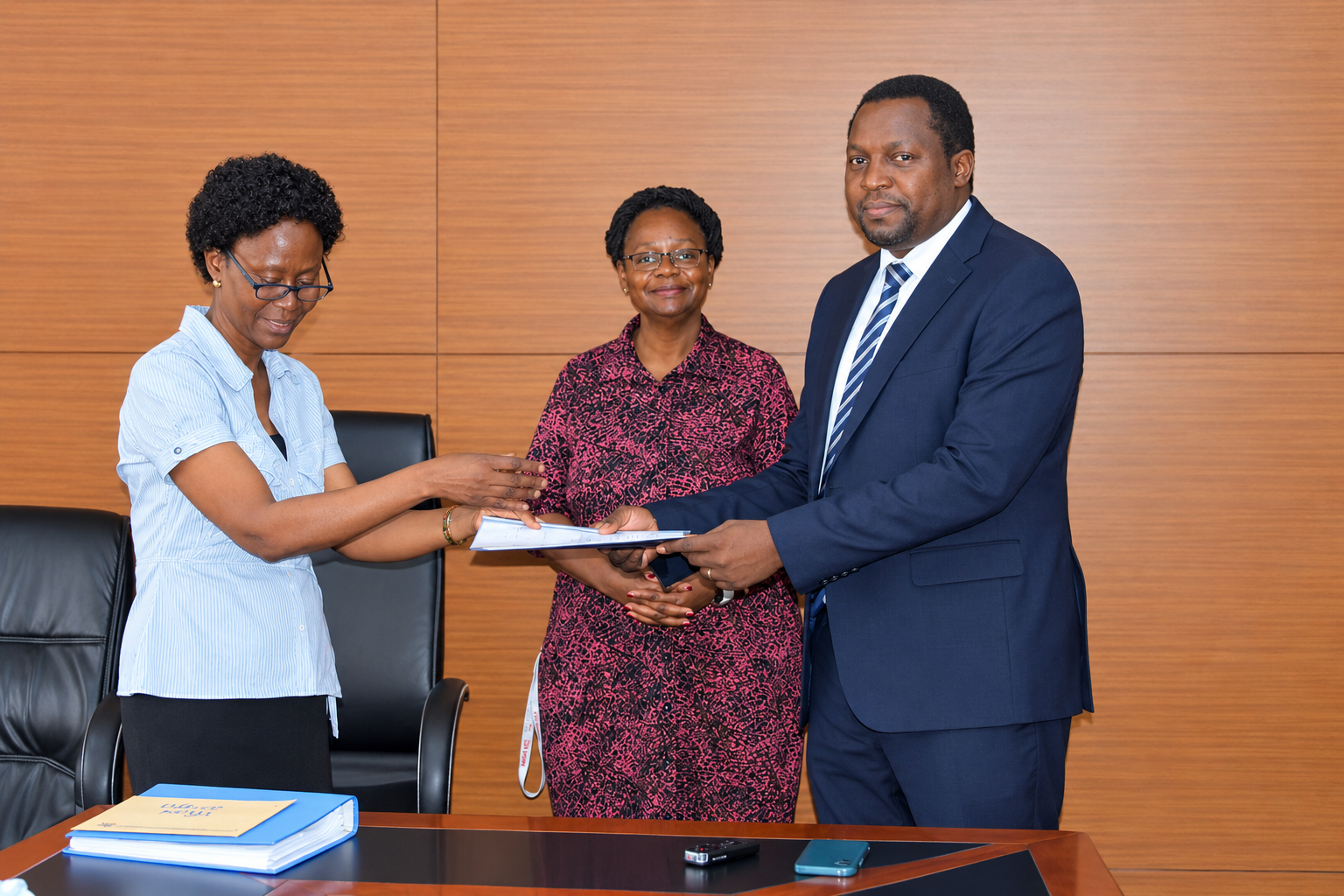 Outgoing Head of Department, Assoc. Prof. Robinah Kulabako (left), hands over the office to the incoming Head of Department, Dr. Philip Nyenje, during a ceremony held at CEDAT on October 5, 2026. In the centre is the Dean, School of Engineering, Assoc. Prof. Eng. Dorothy Okello.